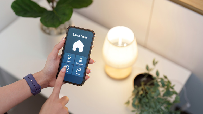 User controlling a smart light with their phone on a mobile app.