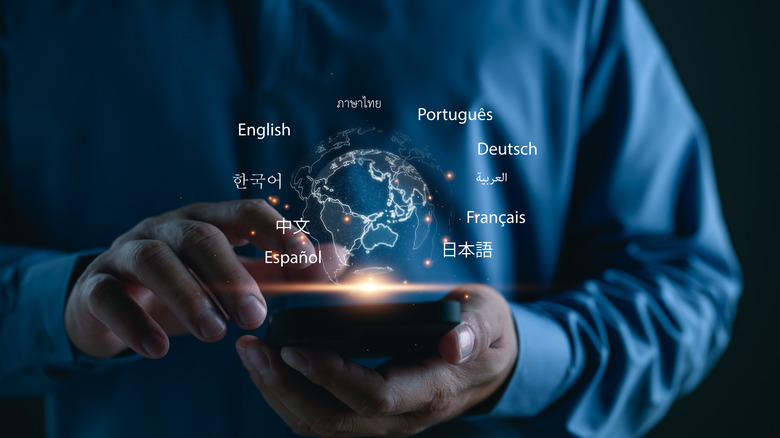 Hand holding phone, with graphics of different languages being displayed.