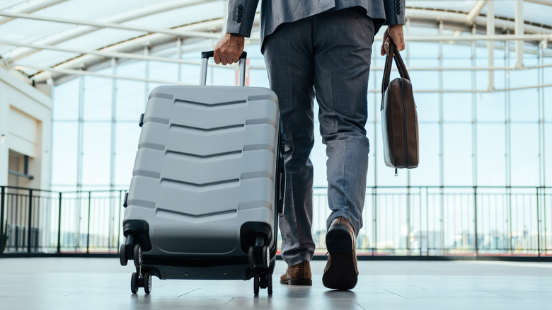 A man pulling his luggage through an airport.