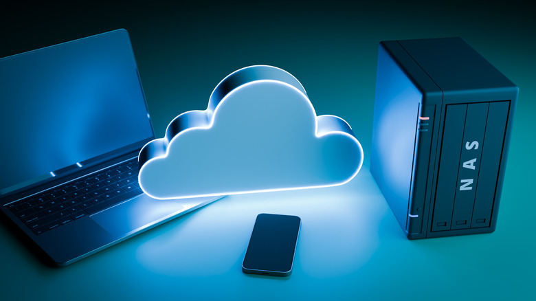 A Laptop is opened, with a phone and NAS device also present on a table.