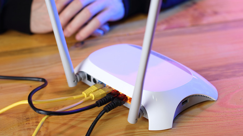 A travel router placed on a table, connected to a LAN.