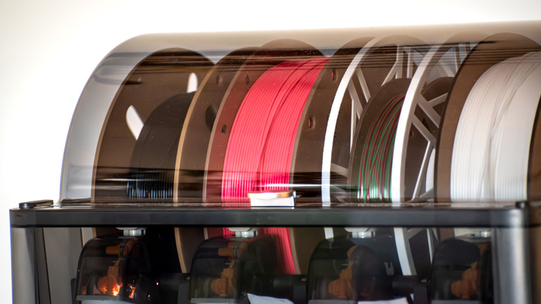 Rolls of 3D printing filament stored in a tray
