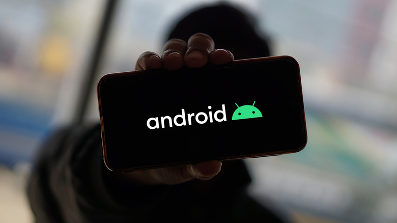 a person showing the Android logo up close on a phone