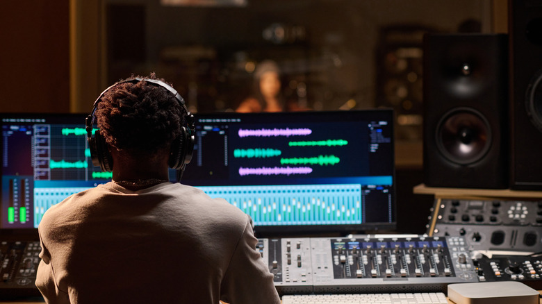 a sound recording studio with a man managing the equipment
