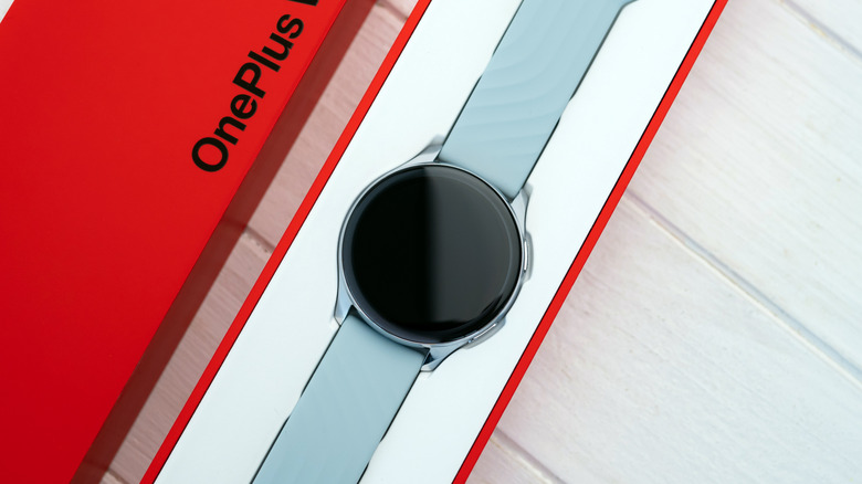 A OnePlus Watch inside a bright red case