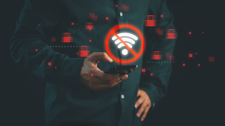 Someone looking down at a smartphone with a no Wi-Fi symbol and locks around it