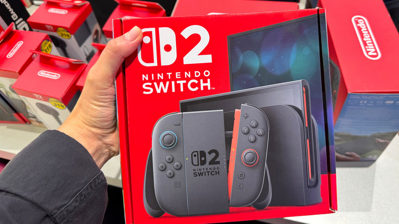 A person holding the box of a new Nintendo Switch console