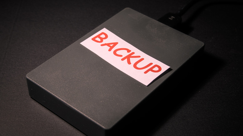 A paper with backup written on it put on top of a hard drive