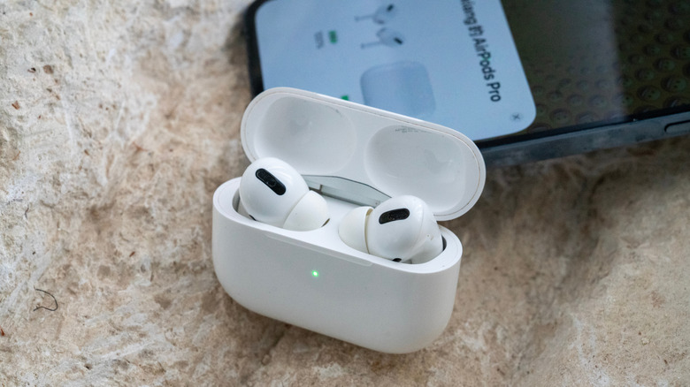 AirPods open next to iPhone showing Battery prompt