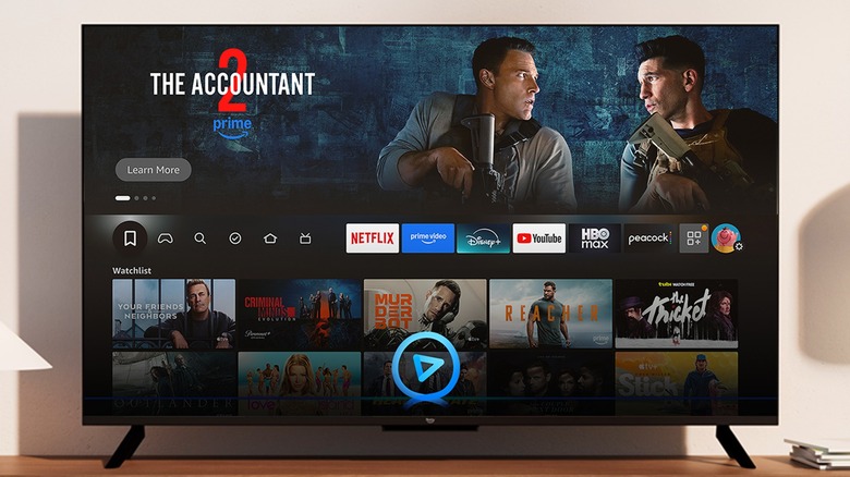 An Amazon Fire TV displaying its Home screen, an advertisement for "The Accountant 2" is prominent on the screen
