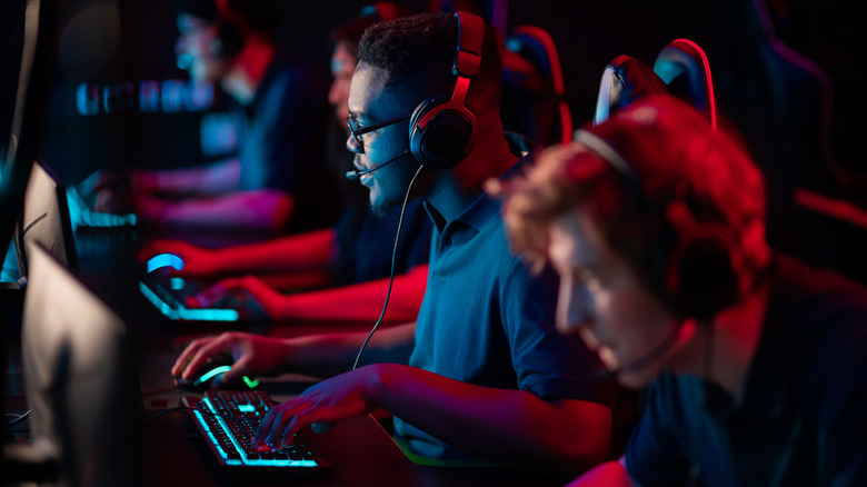 People sitting in a row playing PC games