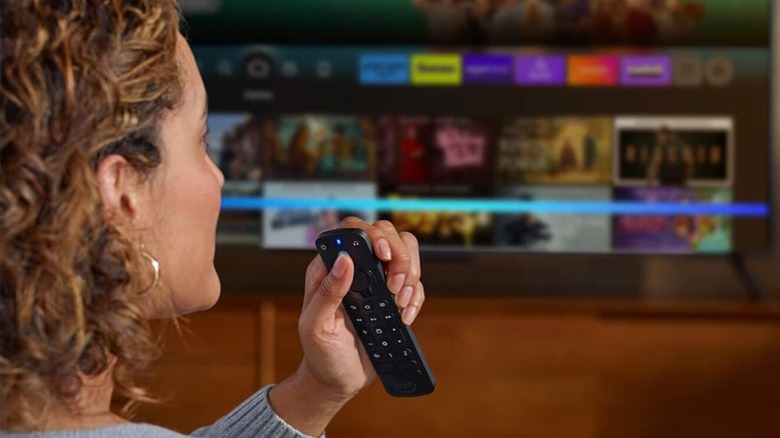 A woman using a Fire TV remote with a customizable button