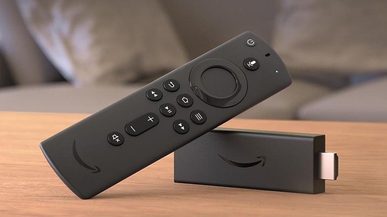 A Fire TV remote on a table with a Fire TV Stick