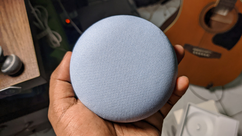 Google Home Mini speaker in a users hand