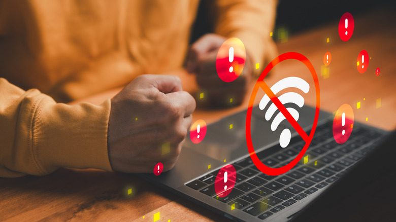 A person using a laptop with Wi-Fi connectivity issues with added graphics to illustrate the issue.