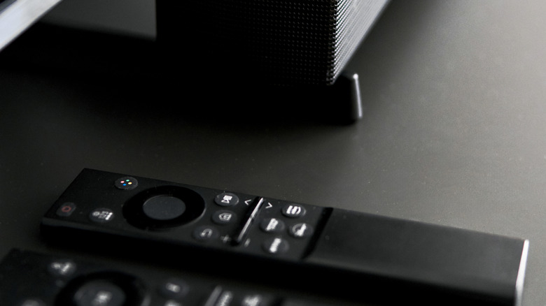 two remotes placed next to a soundbar on a black table