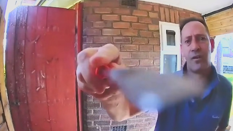 Man using screwdriver to damage Ring doorbell camera