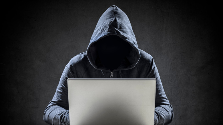 Computer hacker using a laptop