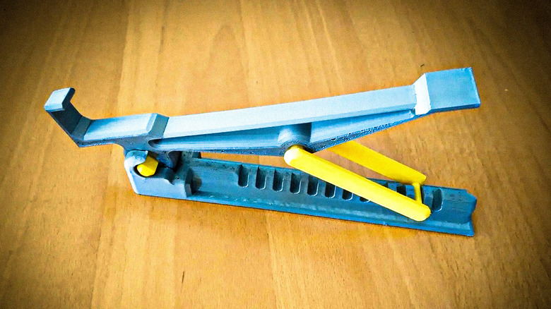 One half of a 3D printed repositionable laptop stand sitting on a wooden surface