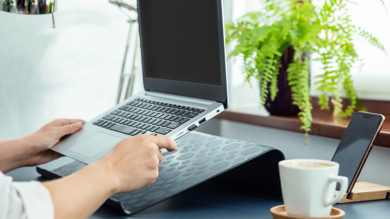 Person placing a laptop on a Laptop stand