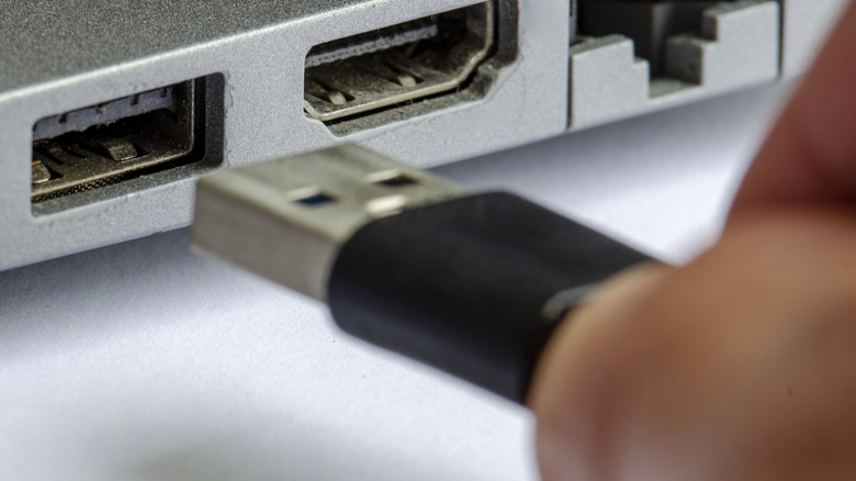 A female USB-A port about to receive a male USB-A cable