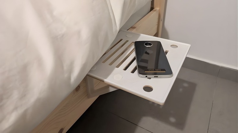 Side bed shelf by TomE8 in use on a pine wood bedframe holding a smartphone.