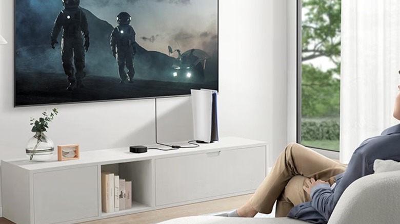 A black Anker 2-in-1 Out HDMI Bi-directional Switcher sits on a white TV stand