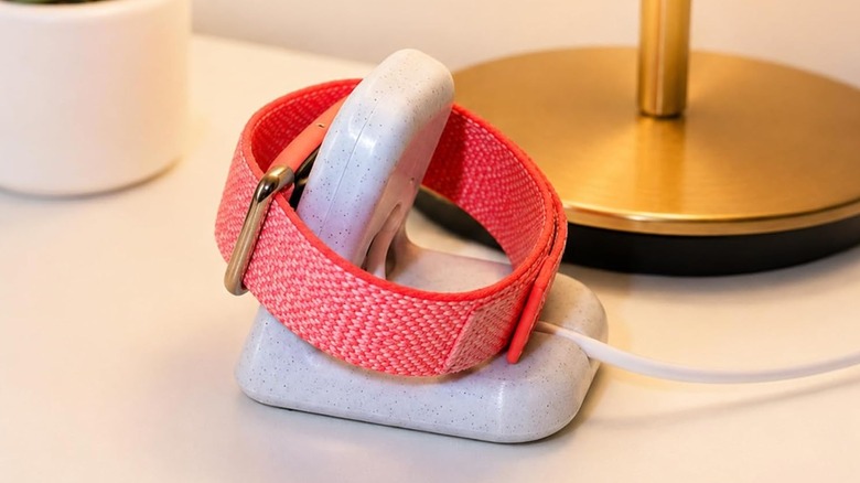 A Fitbit Air charging on a stand.