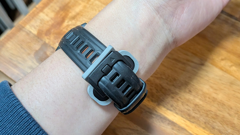A Fitbit Air attached to a wristwatch with a 3D-printed clip.