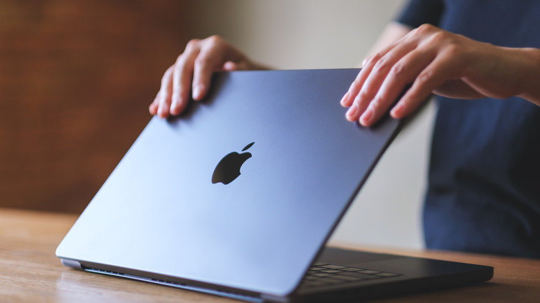 A person openning a MacBook