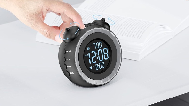 The uscee Loud Dual Alarm Clock with Bed Shaker being set by a person.