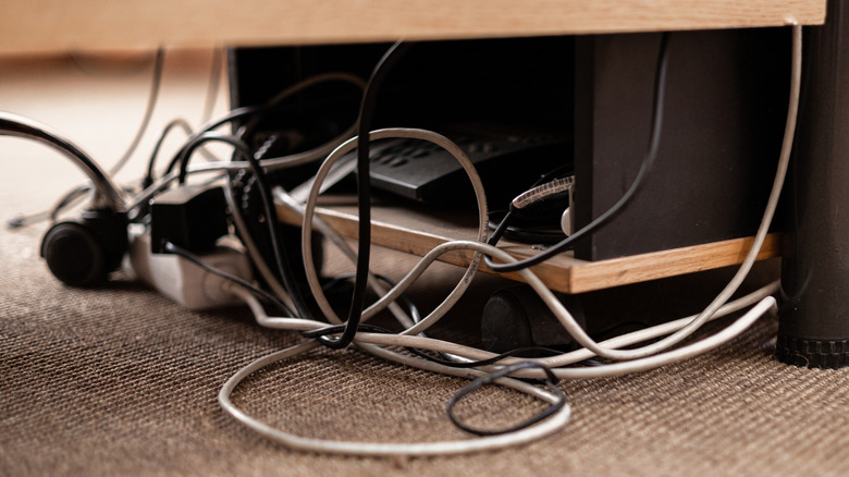 Tangled cables under a desk.