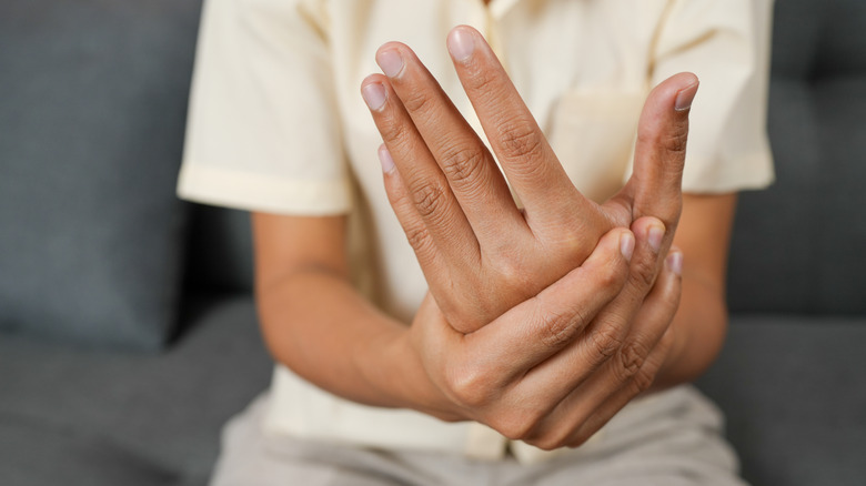 A person holding their wrist in discomfort.