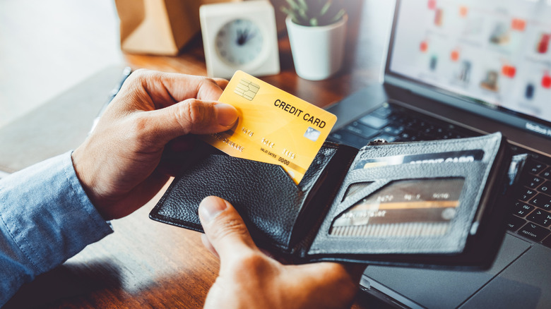 Hand putting credit card inside wallet