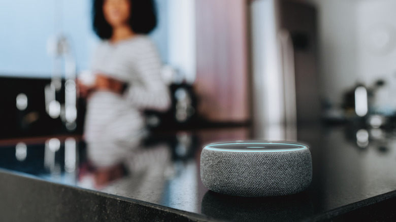 Amazon Alexa-enabled Echo Dot with woman in the background