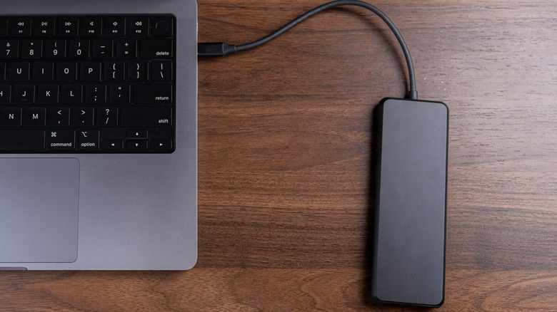 external storage drive connected to a laptop on a wooden desk