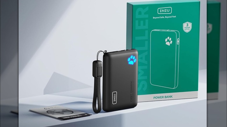 The INIU 45W Flight-Safe Portable Charging sitting on a blue table next to its green and white box