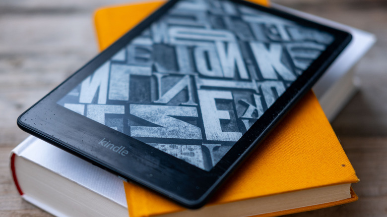 A kindle sitting on top of two books