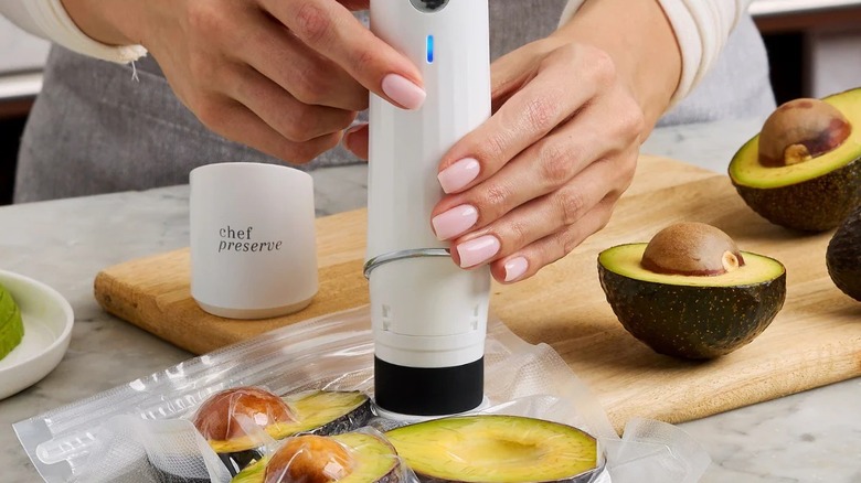 Hands using Chef Preserve Compact Vacuum Sealer for Food to seal avocados