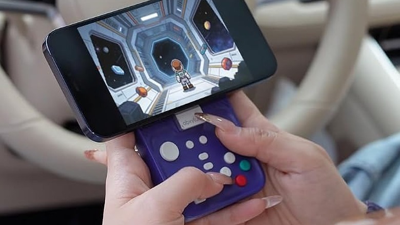 A person using the abxylute M4 Snap-On Mobile Gaming Controller with an iPhone.