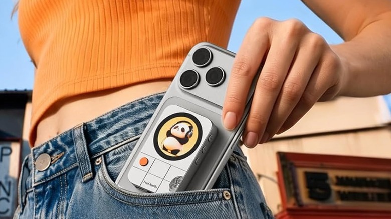 A woman placing an iPhone with an attached Fosi Audio MD3 Headphone Amplifier in her pocket.