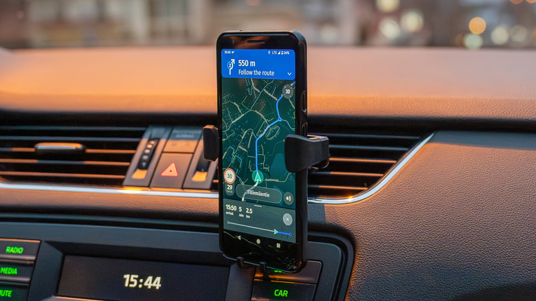 A smartphone in a car held by a phone holder.
