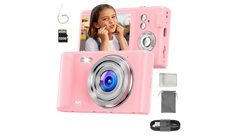 A pink digital camera with accessories on white background