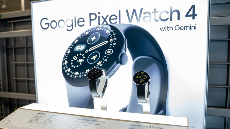 The Pixel Watch 4 on display in a store, with a billboard advertising Google's wearable in the background.