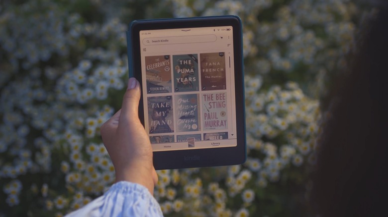 Person in a garden looking at an Amazon Kindle Colorsoft