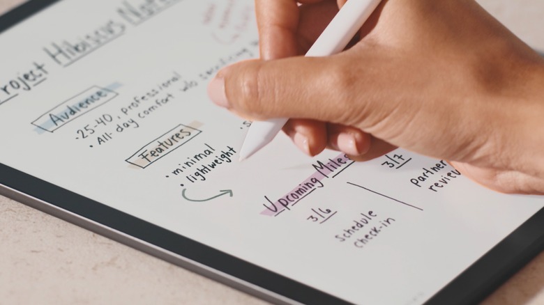 Person drawing arrow on paper with an Amazon Kindle Scribe Colorsoft