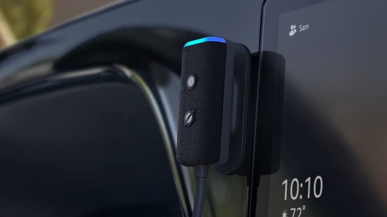 An Amazon Echo Auto mounted next to a car's infotainment system