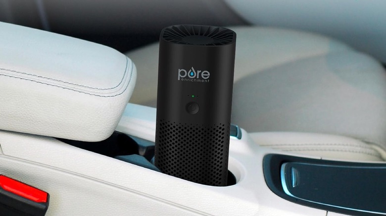 Pure Enrichment PureZone Mini car air purifier placed in a cup holder
