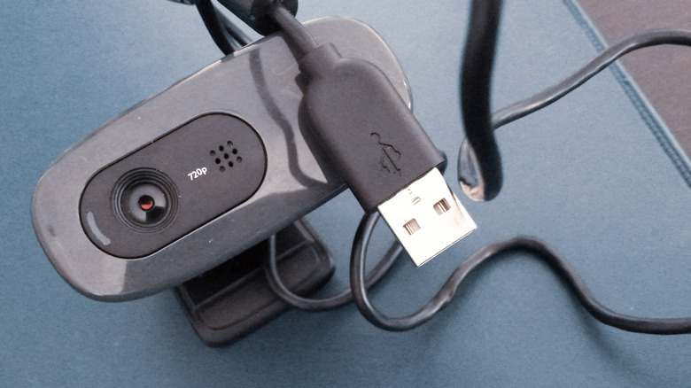 A black webcam with its USB connector on top of it