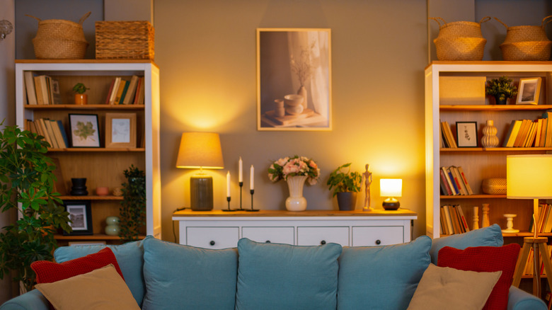 Living room with lamps on in the background.